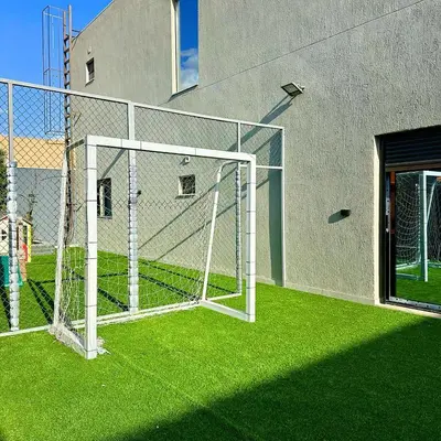 a soccer field with a net in the grass at La Mer Villa by Seahorse in Al Rama