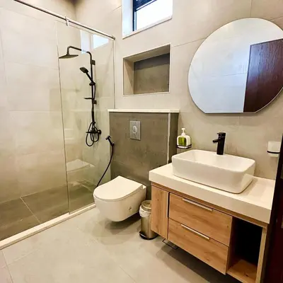 a bathroom with a toilet and a sink and a shower at La Mer Villa by Seahorse in Al Rama