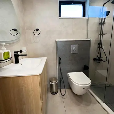 a bathroom with a toilet and a sink and a shower at La Mer Villa by Seahorse in Al Rama