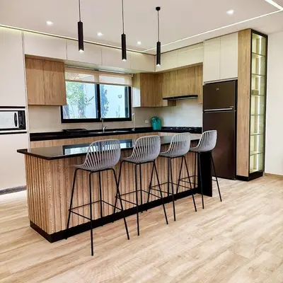 a kitchen with a bar with stools in it at La Mer Villa by Seahorse in Al Rama