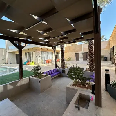 a patio with a purple couch under a pergola at Tonay I Villa by Seahorse in Al Rama