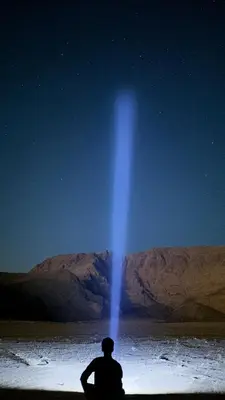 a man sitting on the ground looking at the stars at Wadi Rum Starfield Retreat in Wadi Rum