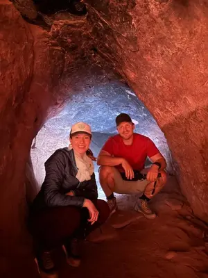 a man and a woman sitting in a cave at Wadi Rum Starfield Retreat in Wadi Rum