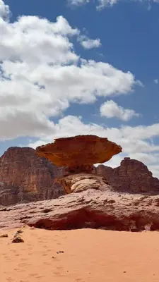 a rock formation in the desert with a sky at Wadi Rum Starfield Retreat in Wadi Rum