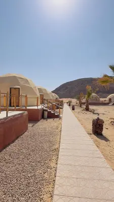 a walkway on a sandy beach with tents at Wadi Rum Starfield Retreat in Wadi Rum