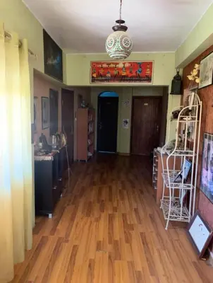 a living room with a hard wood floor and a kitchen at Petra Neighbor Hostel in Petra