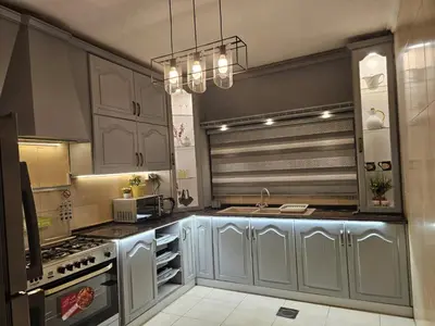 a kitchen with gray cabinets and a sink and a stove at شقة فاخرة في دير غبار in Amman