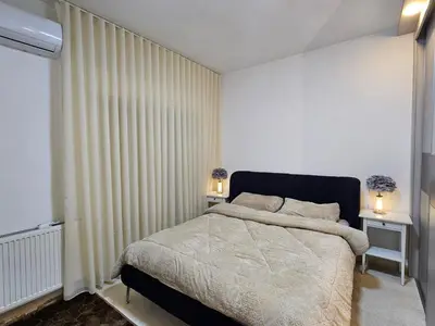 a bedroom with a large bed and two night stands at شقة فاخرة في دير غبار in Amman
