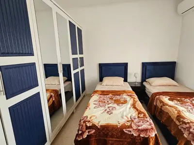 a bedroom with two beds and a mirror at شقة فاخرة في دير غبار in Amman