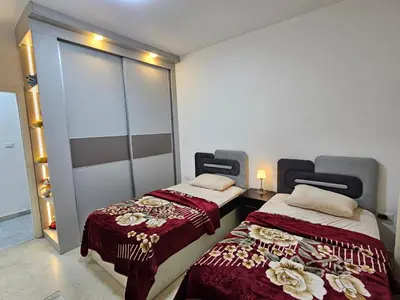 a room with two beds and a sliding glass door at شقة فاخرة في دير غبار in Amman