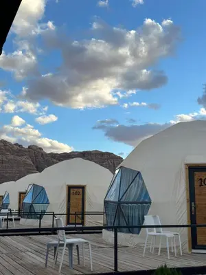 a row of domes with tables and chairs on a deck at The Red Rock Camp in Wadi Rum