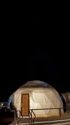 a domed tent with a sign in front of it at The Red Rock Camp in Wadi Rum