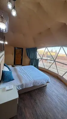 a bedroom with a bed and a large window at The Red Rock Camp in Wadi Rum