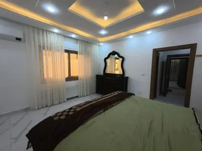 a bedroom with a large bed and a mirror at 220 sqm 3 BR Um Al Summag, Makka Street