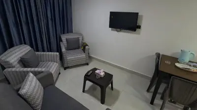 a living room with a couch and chairs and a table at Masaya Al Deyar Apartments in Amman