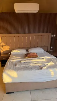 a large bed with a wooden headboard and pillows at sayd camp in Wadi Rum