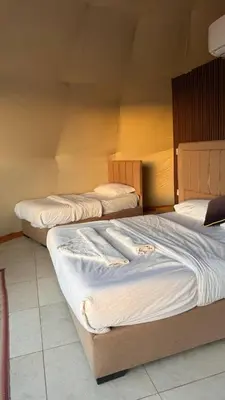 three beds sitting in a room with at sayd camp in Wadi Rum