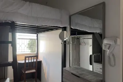a room with a bunk bed with a chair and a phone at Modern Loft Studio Panoramic Views And Smart Design in Amman