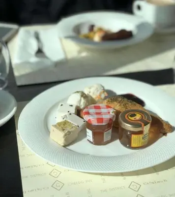 a plate of food with cheese and jam and butter at Wadi Rum Ahmad comp in Wadi Rum
