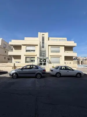 three cars parked in a parking lot in front of a building at 2 BR 100 sqm Modern Apt Abdoun in Amman