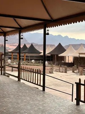 a view of a desert with tents and mountains at Imperial Rum Luxury Camp in Wadi Rum