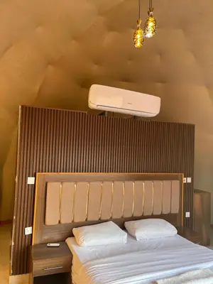 a bedroom with a bed with a large wooden headboard at Imperial Rum Luxury Camp in Wadi Rum