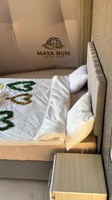 a bed with white sheets and pillows in a room at MAYA RUM LUXURY CAMP & Jeep Tours in Disah
