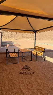 two benches under a large umbrella on the beach at MAYA RUM LUXURY CAMP & Jeep Tours in Disah