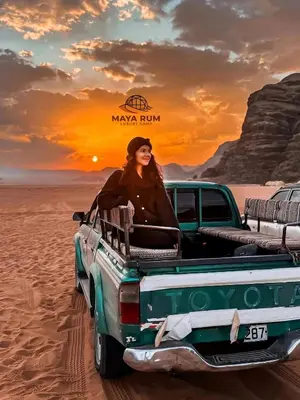 a woman sitting in the back of a truck in the desert at MAYA RUM LUXURY CAMP & Jeep Tours in Disah