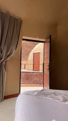a bedroom with a bed and an open door at Red Moon Camp in Wadi Rum