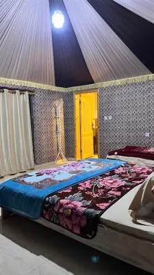 a large bed in a room with a yellow door at Red Moon Camp in Wadi Rum