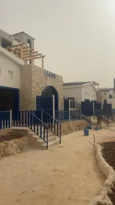 a building with a blue fence and a gate at Santorini Resort & Spa in Sowayma