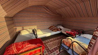 a small room with two beds in a tent at Wadi Rum Desert Night Camp in Wadi Rum