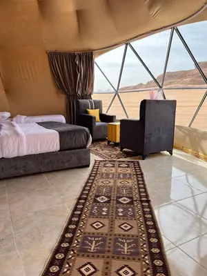 a bedroom with a bed and chairs and a rug at Rina Luxury Camp in Disah