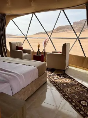 a bedroom in a tent with a bed and chairs at Rina Luxury Camp in Disah