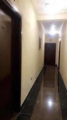 a hallway of a building with a door and a hallwayngth at Al Tawheed Hotel Apartments in Amman
