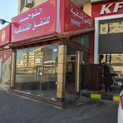 a man standing in front of a store front at Al Tawheed Hotel Apartments in Amman