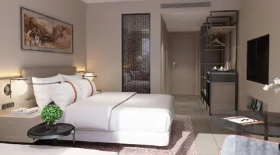 a bedroom with a white bed and a living room at Crowne Plaza Resort Petra by IHG in Wadi Musa