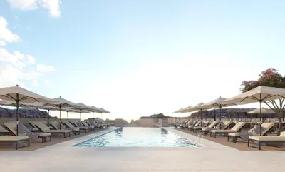 a swimming pool with lounge chairs and umbrellas at Crowne Plaza Resort Petra by IHG in Wadi Musa