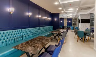 a dining room with purple walls and tables and chairs at Nishan Hotel in Amman