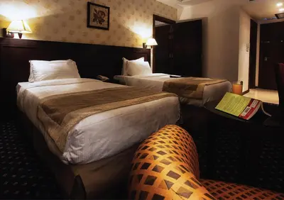 a hotel room with two beds and a couch at Seven Roses Hotel in Amman