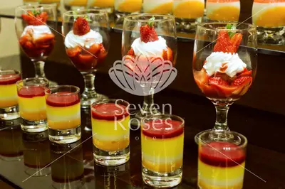a group of glasses filled with different types of desserts at Seven Roses Hotel in Amman