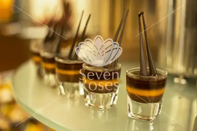 a row of glasses with a drink on a counter at Seven Roses Hotel in Amman