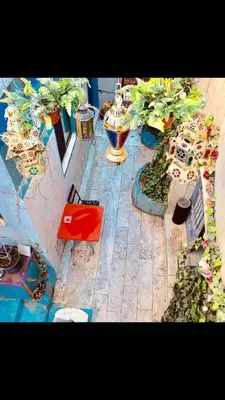 a patio with potted plants and a red chair at Zaman Ya Zaman Boutique Hotel in Amman