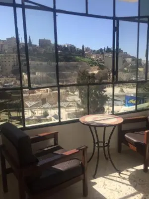 a room with a table and chairs and a large window at Zaman Ya Zaman Boutique Hotel in Amman