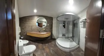 a bathroom with a toilet and a sink and a tub at Le Vendome Hotel in Amman