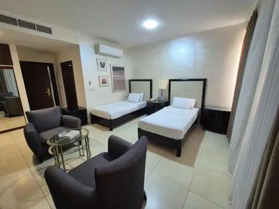 a hotel room with a bed and a couch and chairs at Le Vendome Hotel in Amman