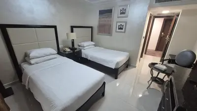 a hotel room with two beds and a mirror at Le Vendome Hotel in Amman