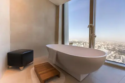 a bath tub in a bathroom with a large window at Amman Rotana in Amman