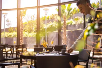 a man sitting at a table in a restaurant at Amman Rotana in Amman